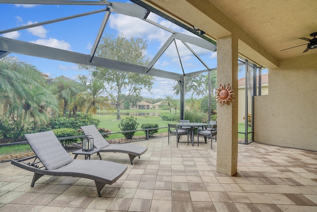 view of patio with glass enclosure and ceiling fan