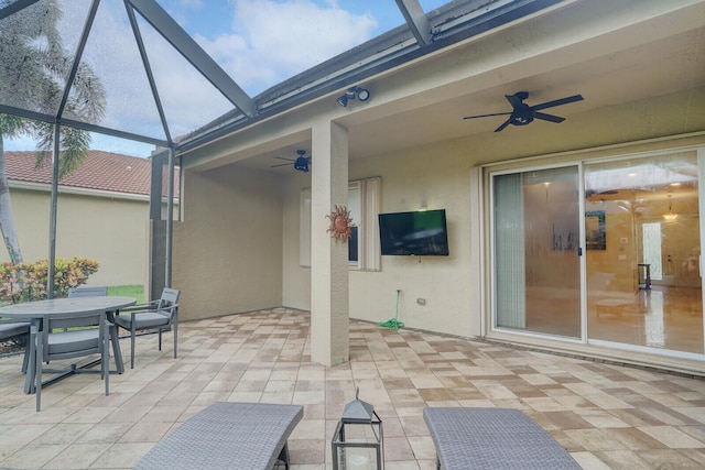 view of patio featuring ceiling fan and a lanai