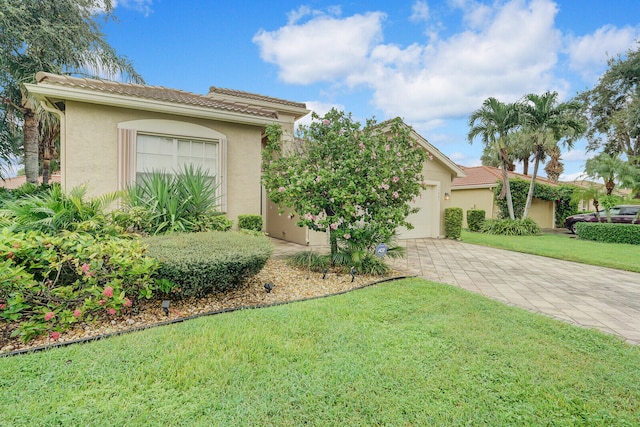 view of front of home with a garage and a front lawn