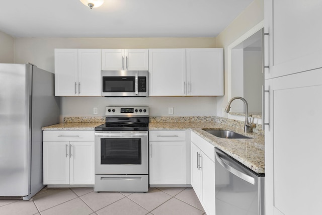 kitchen featuring white cabinets, sink, light tile patterned floors, and stainless steel appliances