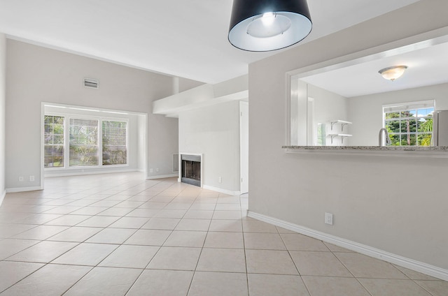 unfurnished living room with light tile patterned floors and sink