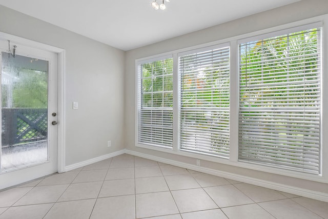 tiled spare room with a healthy amount of sunlight