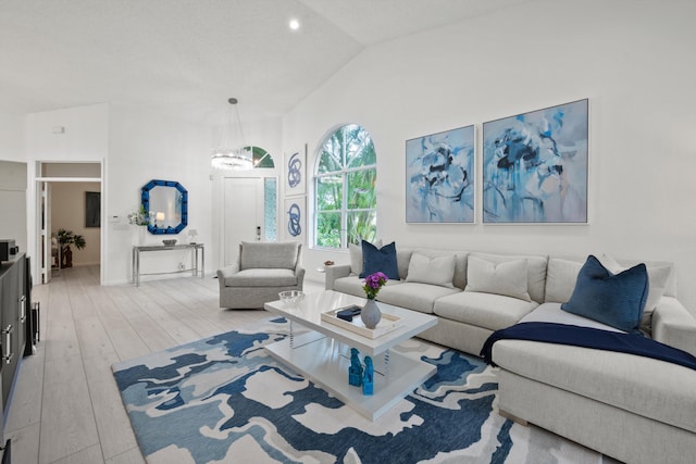 4561 Carlton Golf Dr, Lake Worth, FL 33449 - living area featuring vaulted ceiling, light wood finished floors, baseboards, and a notable chandelier