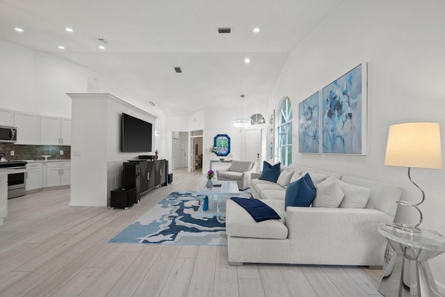 4561 Carlton Golf Dr, Lake Worth, FL 33449 - living area featuring light wood finished floors, an inviting chandelier, visible vents, and high vaulted ceiling