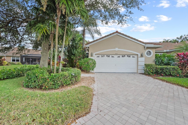 4561 Carlton Golf Dr, Lake Worth, FL 33449 - view of front facade with decorative driveway, a front lawn, a tiled roof, an attached garage, and stucco siding