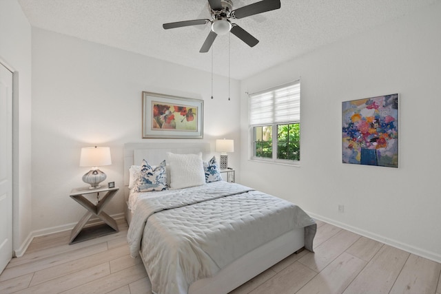 4561 Carlton Golf Dr, Lake Worth, FL 33449 - bedroom with baseboards, a ceiling fan, a textured ceiling, and light wood-style flooring