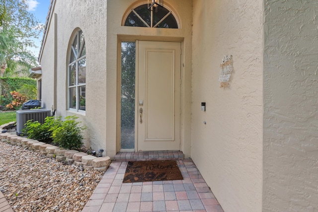 4561 Carlton Golf Dr, Lake Worth, FL 33449 - doorway to property with central AC and stucco siding
