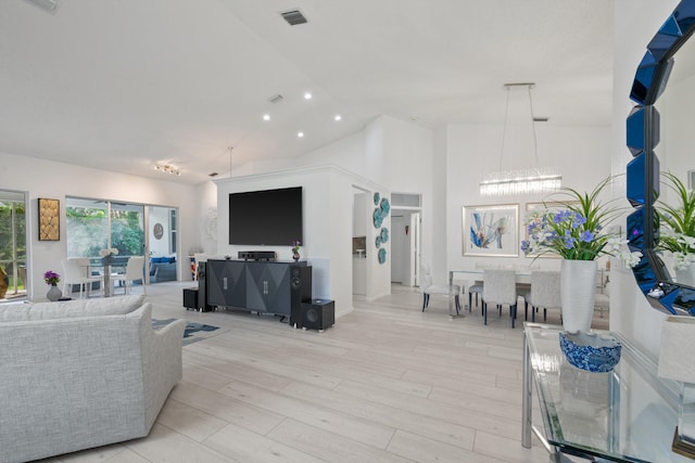 4561 Carlton Golf Dr, Lake Worth, FL 33449 - living area featuring light wood-style flooring, visible vents, high vaulted ceiling, and a notable chandelier