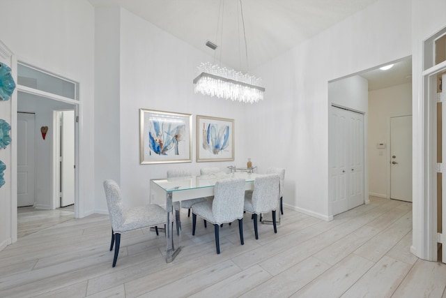 4561 Carlton Golf Dr, Lake Worth, FL 33449 - dining room with a chandelier, wood finished floors, a towering ceiling, and baseboards