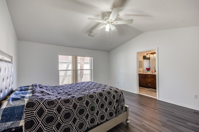 bedroom featuring ceiling fan, dark wood-type flooring, ensuite bathroom, and vaulted ceiling