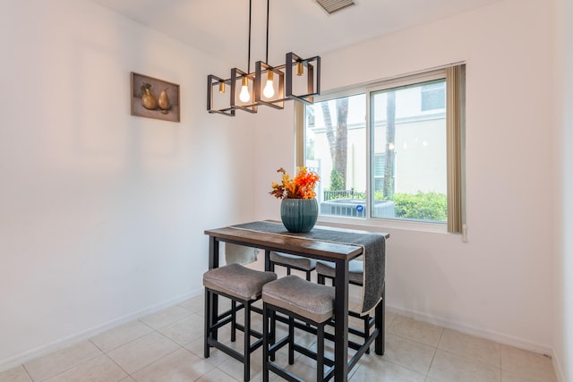 tiled dining room with a chandelier