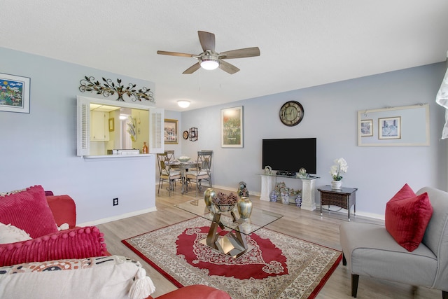 living room with ceiling fan and light hardwood / wood-style flooring