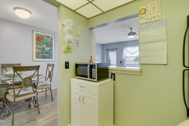 laundry room with light wood-type flooring and ceiling fan