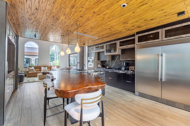 kitchen featuring wooden ceiling, tasteful backsplash, light hardwood / wood-style flooring, stainless steel built in refrigerator, and pendant lighting