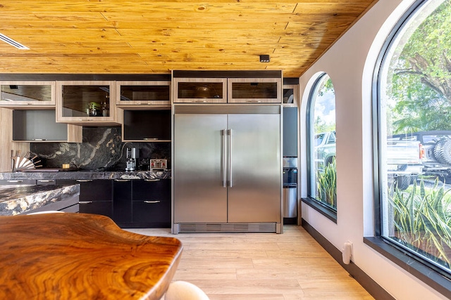 kitchen with hanging light fixtures, stainless steel built in refrigerator, decorative backsplash, wood ceiling, and light wood-type flooring