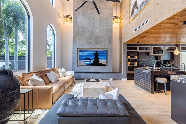 living room with hardwood / wood-style floors, sink, and a high ceiling