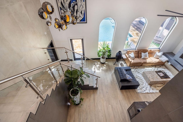 living room featuring light wood-type flooring and a towering ceiling