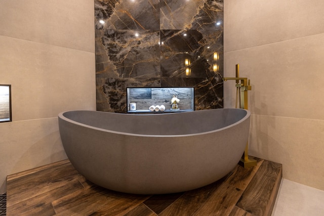 interior space with tile walls and a tub