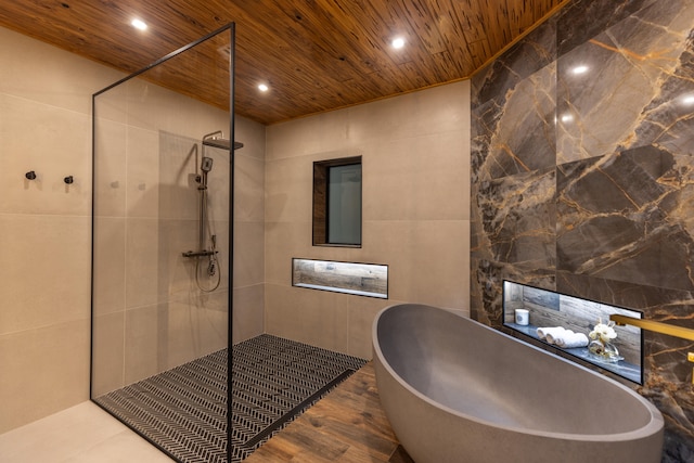 bathroom with shower with separate bathtub, wood-type flooring, tile walls, and wooden ceiling