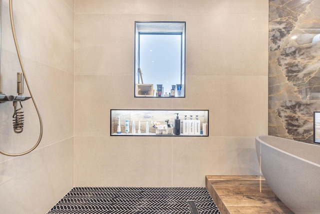 bathroom featuring shower with separate bathtub and tile walls