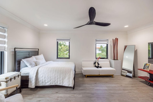 bedroom featuring multiple windows, ceiling fan, and light hardwood / wood-style flooring