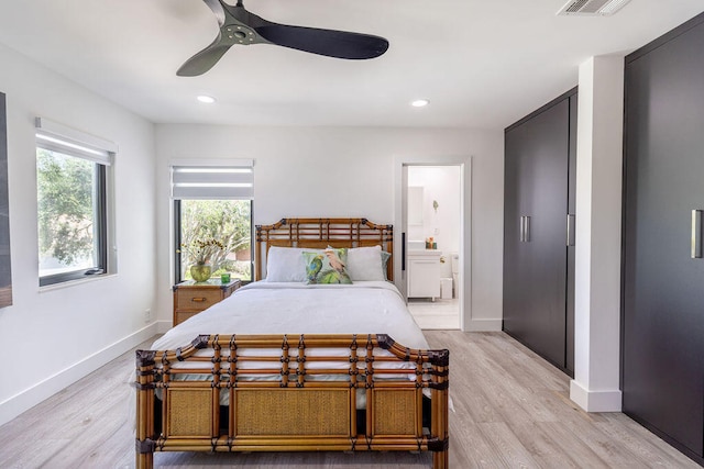 bedroom with ensuite bathroom, light hardwood / wood-style flooring, and ceiling fan