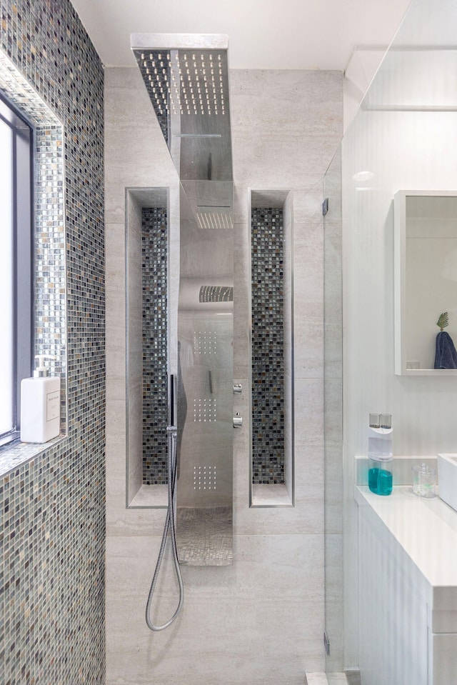 bathroom featuring a tile shower and tile walls