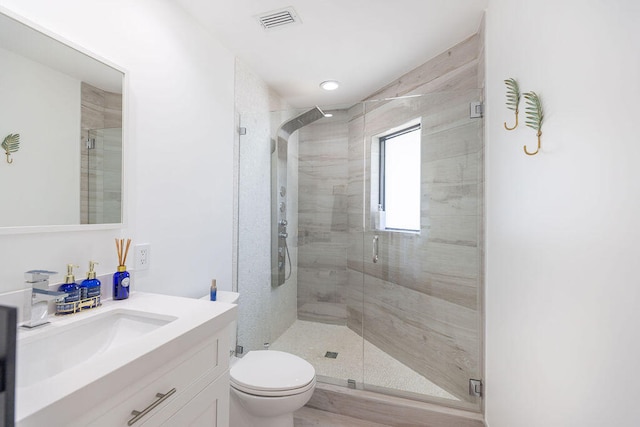 bathroom with hardwood / wood-style floors, vanity, toilet, and a shower with door