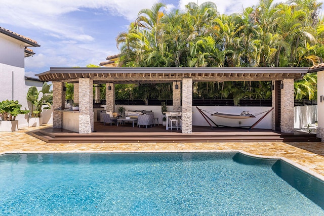 view of swimming pool featuring exterior bar, an outdoor hangout area, and a patio area