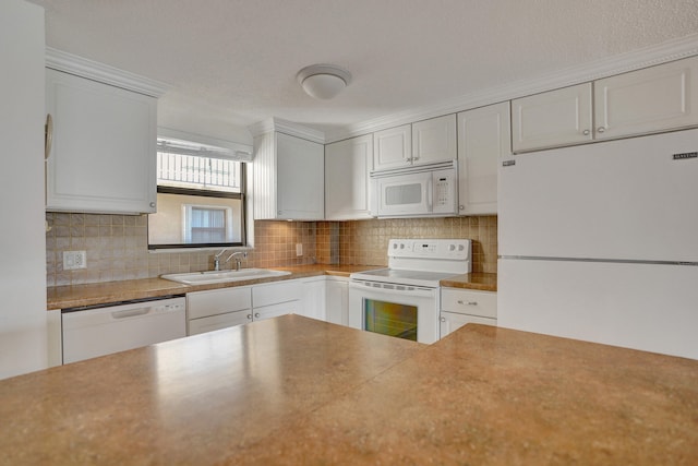 kitchen featuring tasteful backsplash, white appliances, sink, and white cabinetry