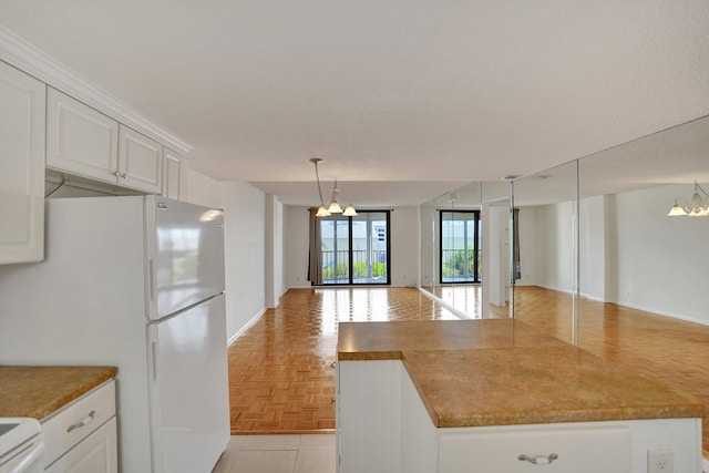 kitchen with an inviting chandelier, white appliances, light parquet floors, hanging light fixtures, and white cabinets