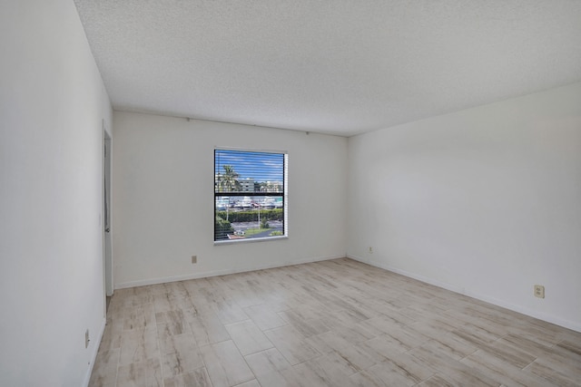 empty room featuring light hardwood / wood-style floors and a textured ceiling