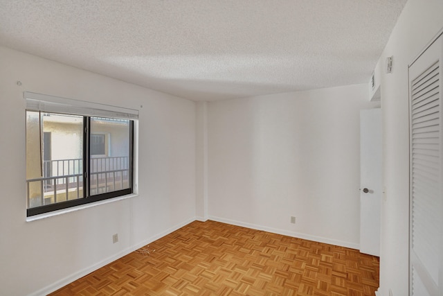 spare room with a textured ceiling and light parquet floors