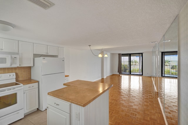 kitchen featuring decorative backsplash, white appliances, white cabinetry, and a textured ceiling