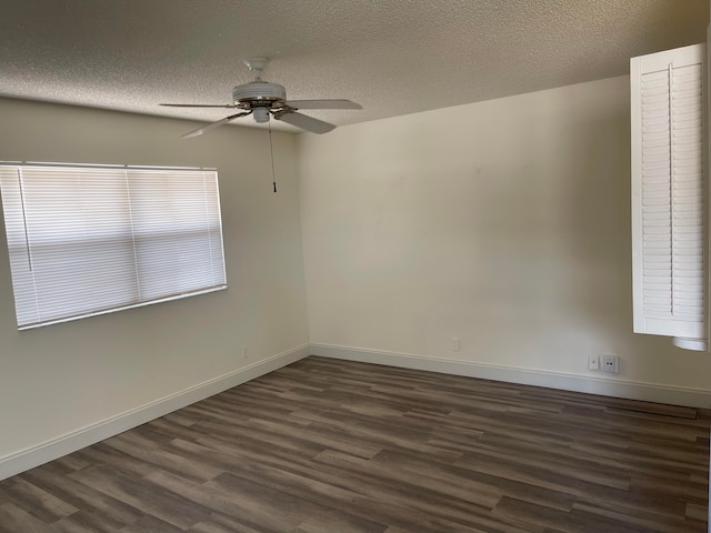 empty room featuring ceiling fan, a textured ceiling, and dark wood-type flooring