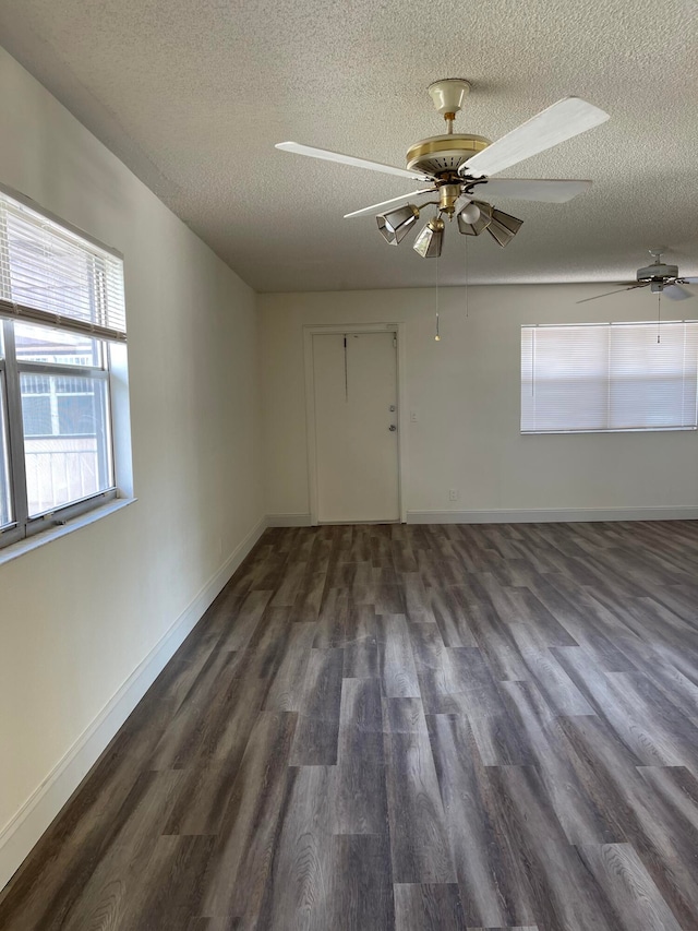 spare room featuring ceiling fan, dark hardwood / wood-style floors, and a textured ceiling