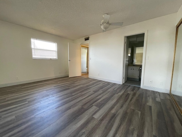 unfurnished bedroom with dark hardwood / wood-style floors, ensuite bathroom, a textured ceiling, and ceiling fan