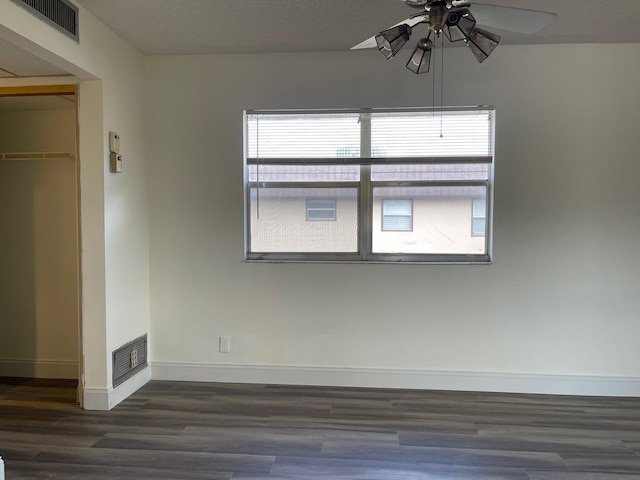 unfurnished room featuring dark hardwood / wood-style flooring, a textured ceiling, and ceiling fan