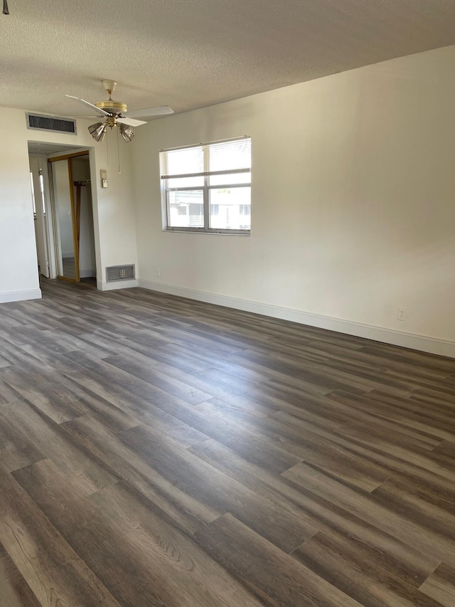 spare room with ceiling fan, dark hardwood / wood-style flooring, and a textured ceiling