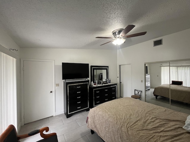 bedroom with light tile patterned flooring, a textured ceiling, and ceiling fan