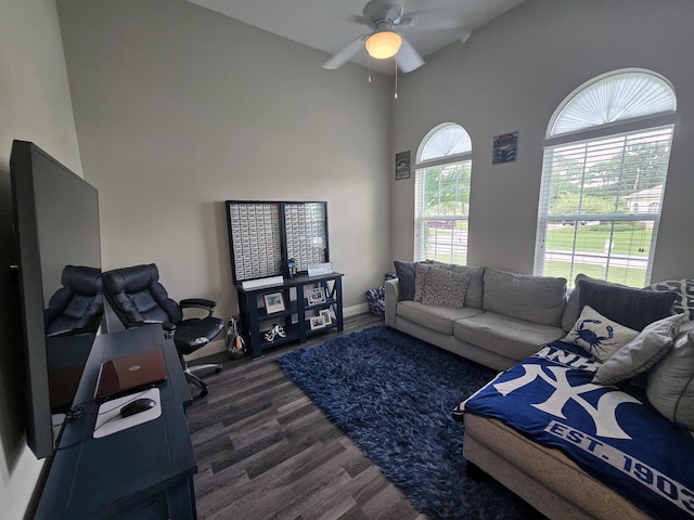 living room featuring dark wood-type flooring and ceiling fan