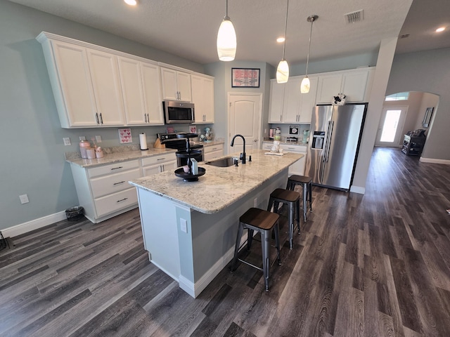 kitchen with stainless steel appliances, dark wood-type flooring, sink, and white cabinetry