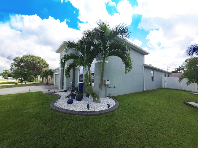 view of side of property featuring a garage and a yard