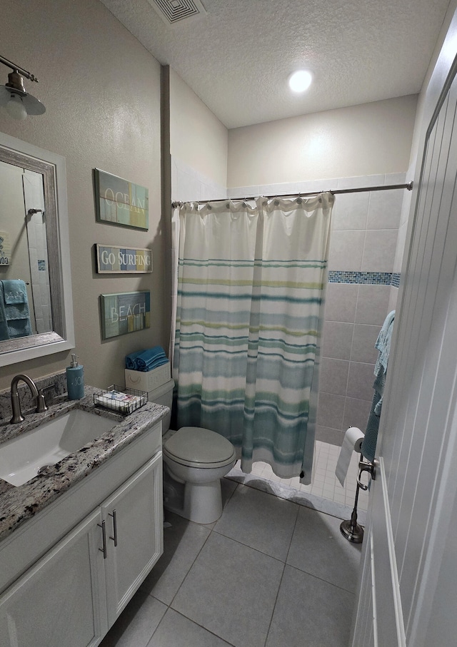 bathroom with tile patterned flooring, toilet, a shower with shower curtain, vanity, and a textured ceiling