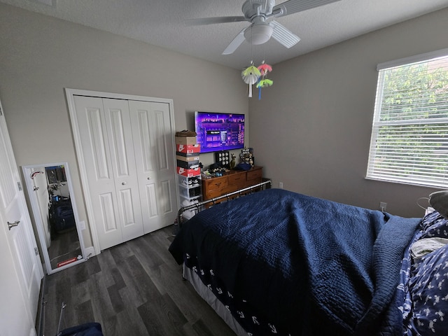 bedroom featuring a closet, dark hardwood / wood-style floors, a textured ceiling, and ceiling fan