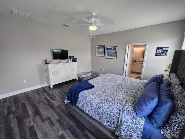 bedroom with ceiling fan, a textured ceiling, dark wood-type flooring, and ensuite bathroom