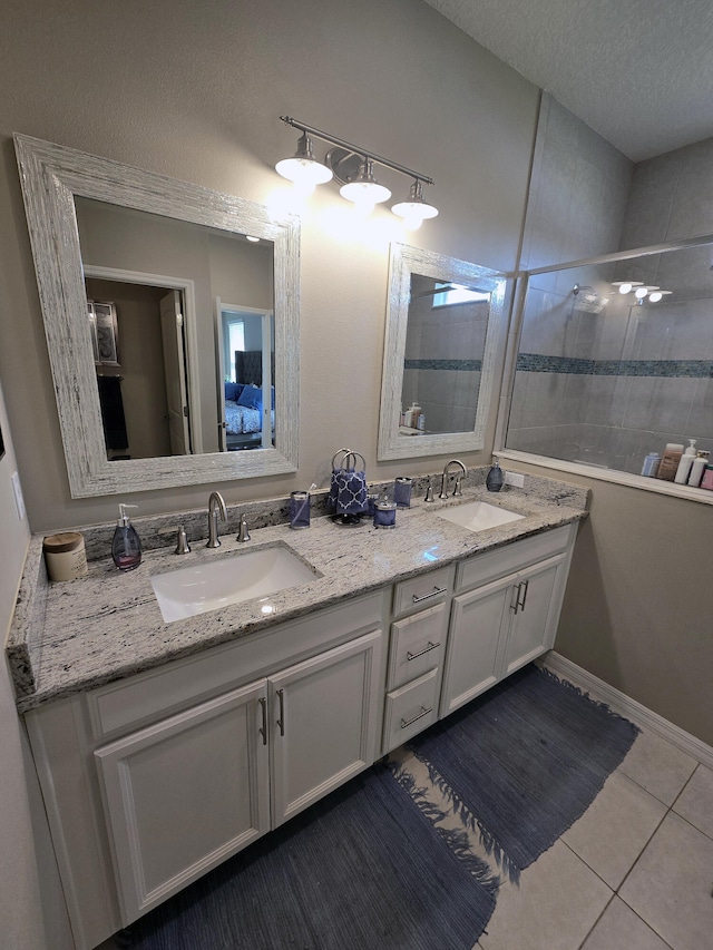 bathroom with vanity, tile patterned flooring, a textured ceiling, and tiled shower