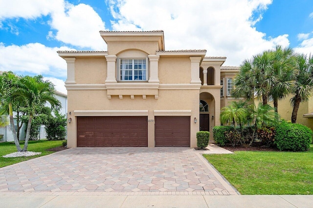 mediterranean / spanish-style home featuring a garage and a front lawn