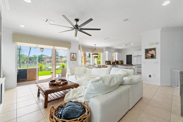 tiled living room featuring ceiling fan, a textured ceiling, and crown molding