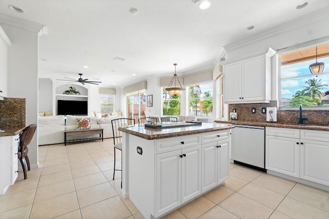 kitchen featuring white cabinets, dishwasher, crown molding, and a center island